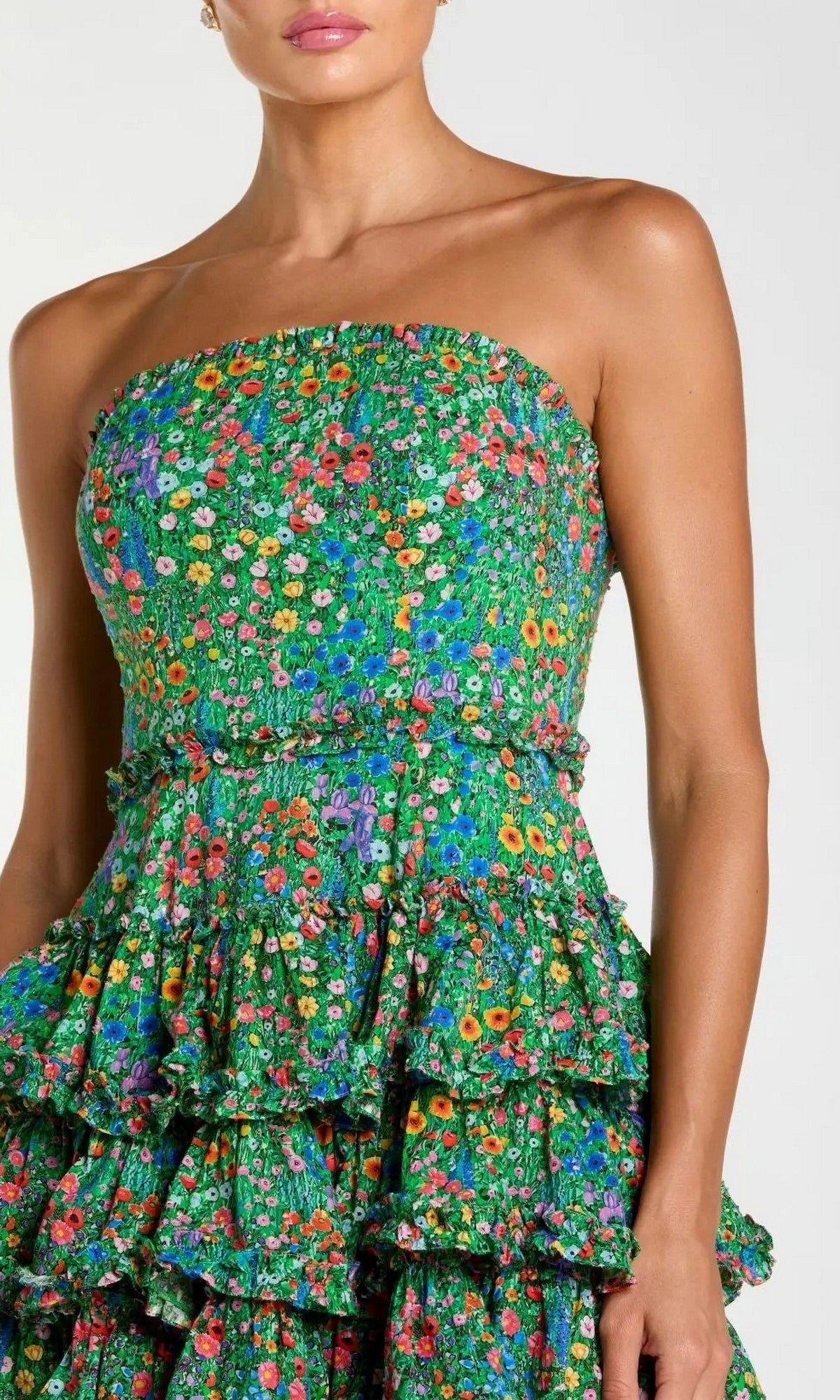 A woman wearing the Mac Duggal 8459 Tea-Length Party Dress—a strapless cotton dress with a colorful floral print and tiered ruffle skirt, perfectly capturing playful elegance.